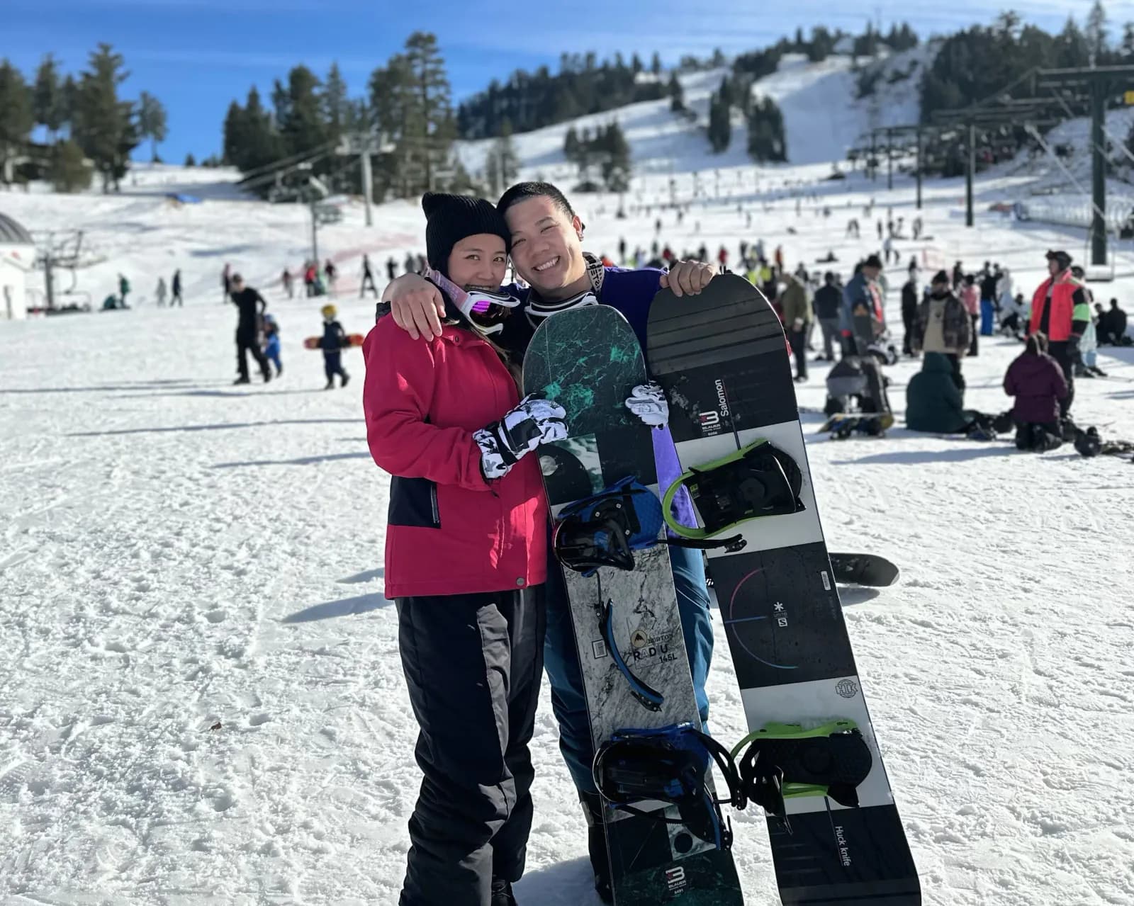 Christine and Thomas holding their snowboards at a ski resort