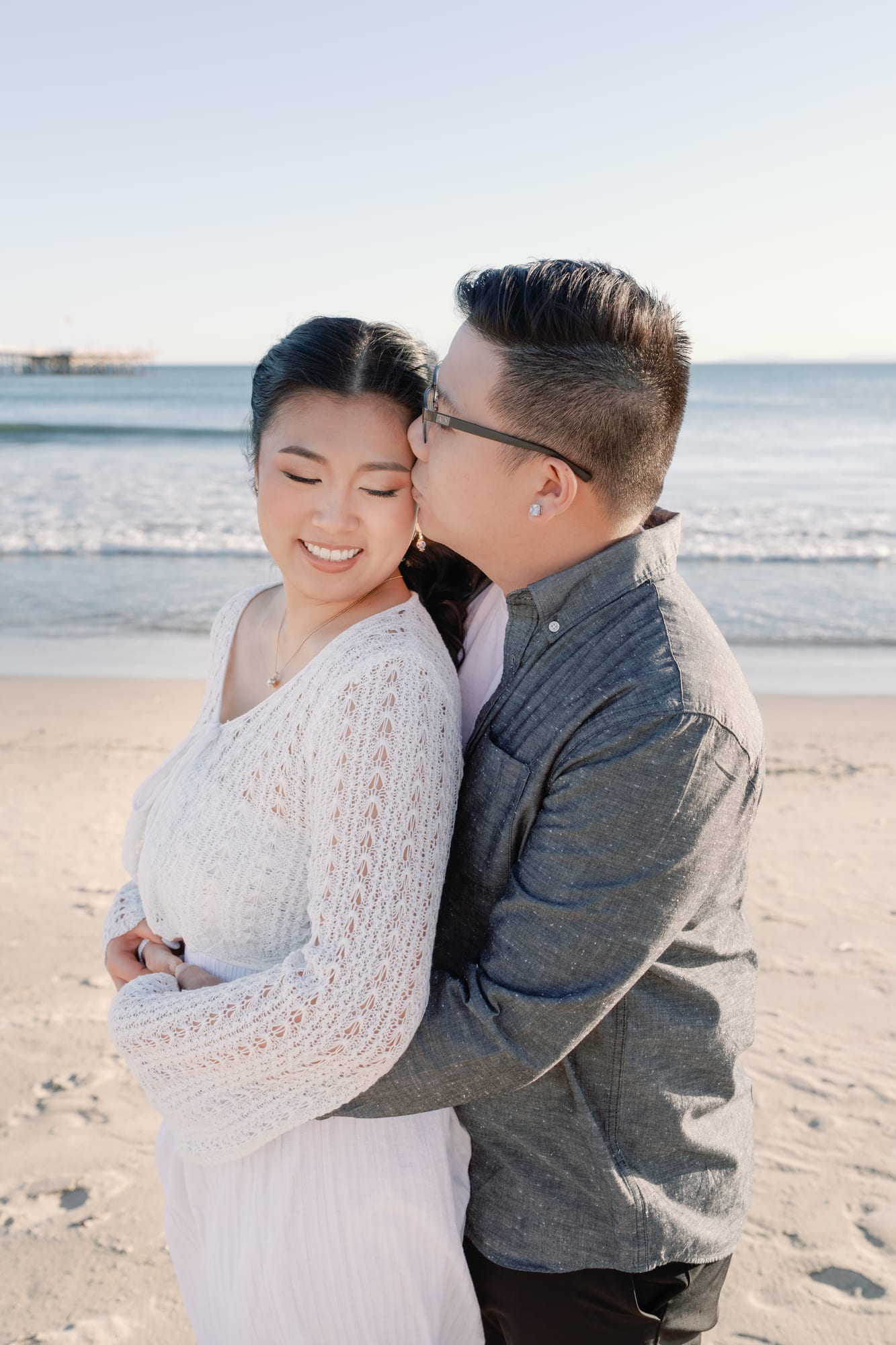 Thomas kissing Christine's cheek as she smiles.