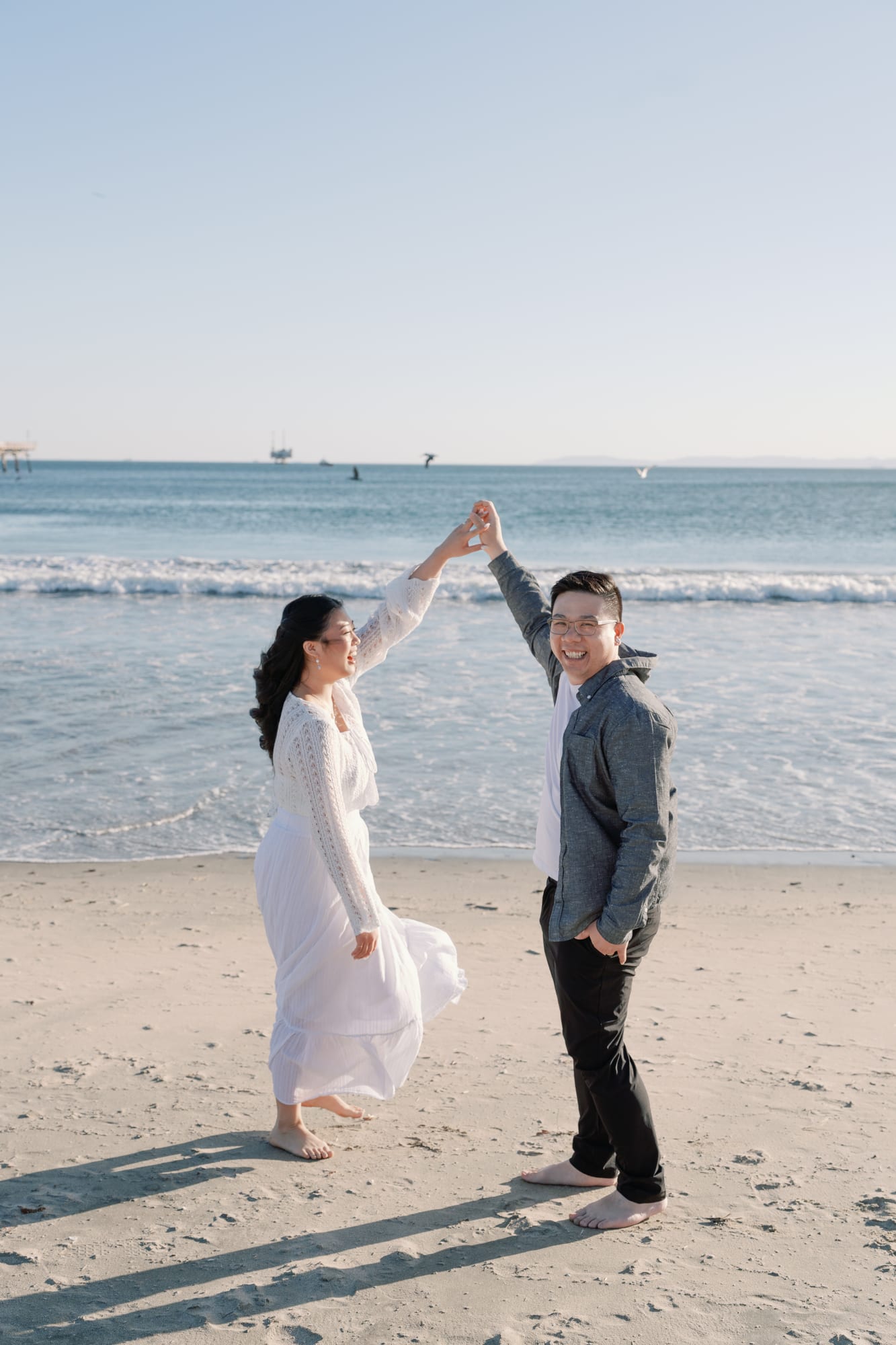 Thomas twirling Christine on the sand.